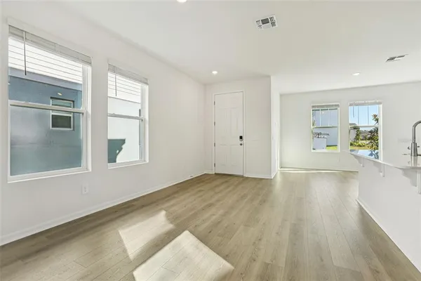 a view of kitchen with cabinets appliances wooden floor and window