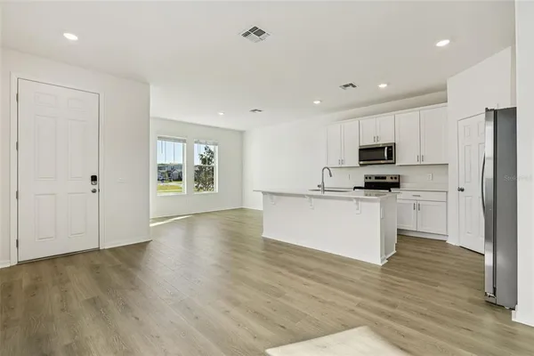 a view of kitchen with wooden floor and electronic appliances