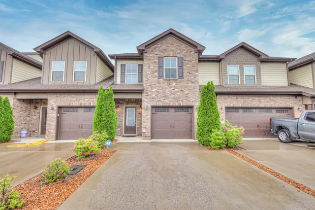 a front view of a house with a garden and garage