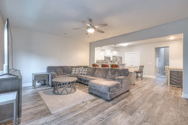 a living room with furniture and a wooden floor