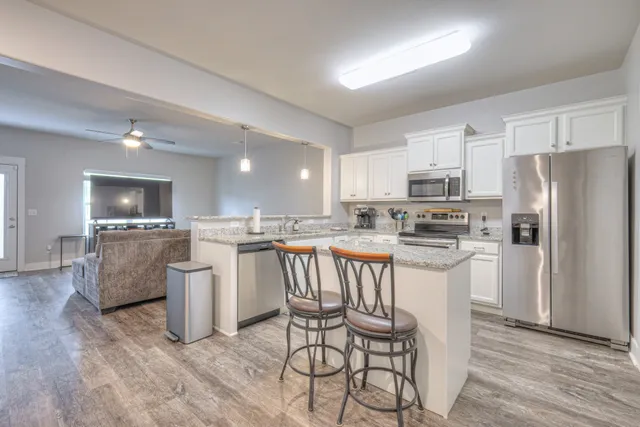 a kitchen with kitchen island white cabinets and stainless steel appliances