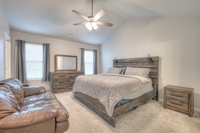 a bedroom with two large bed and a ceiling fan