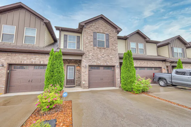 a view of a backyard with plants and a white house