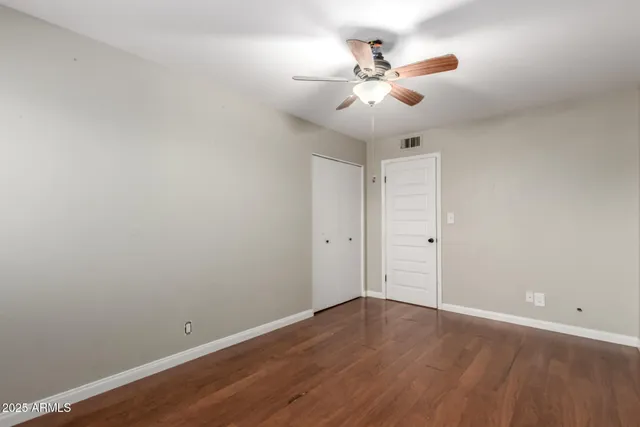 a view of a room with wooden floor and ceiling fan