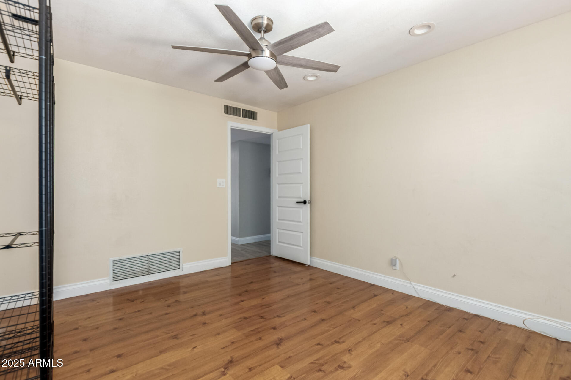 3045 East Cholla Street Phoenix, AZ 85028 - Photo 17 of 23 an empty room with wooden floor and a ceiling fan