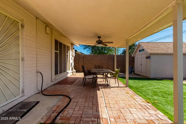 a patio with table and chairs and potted plants