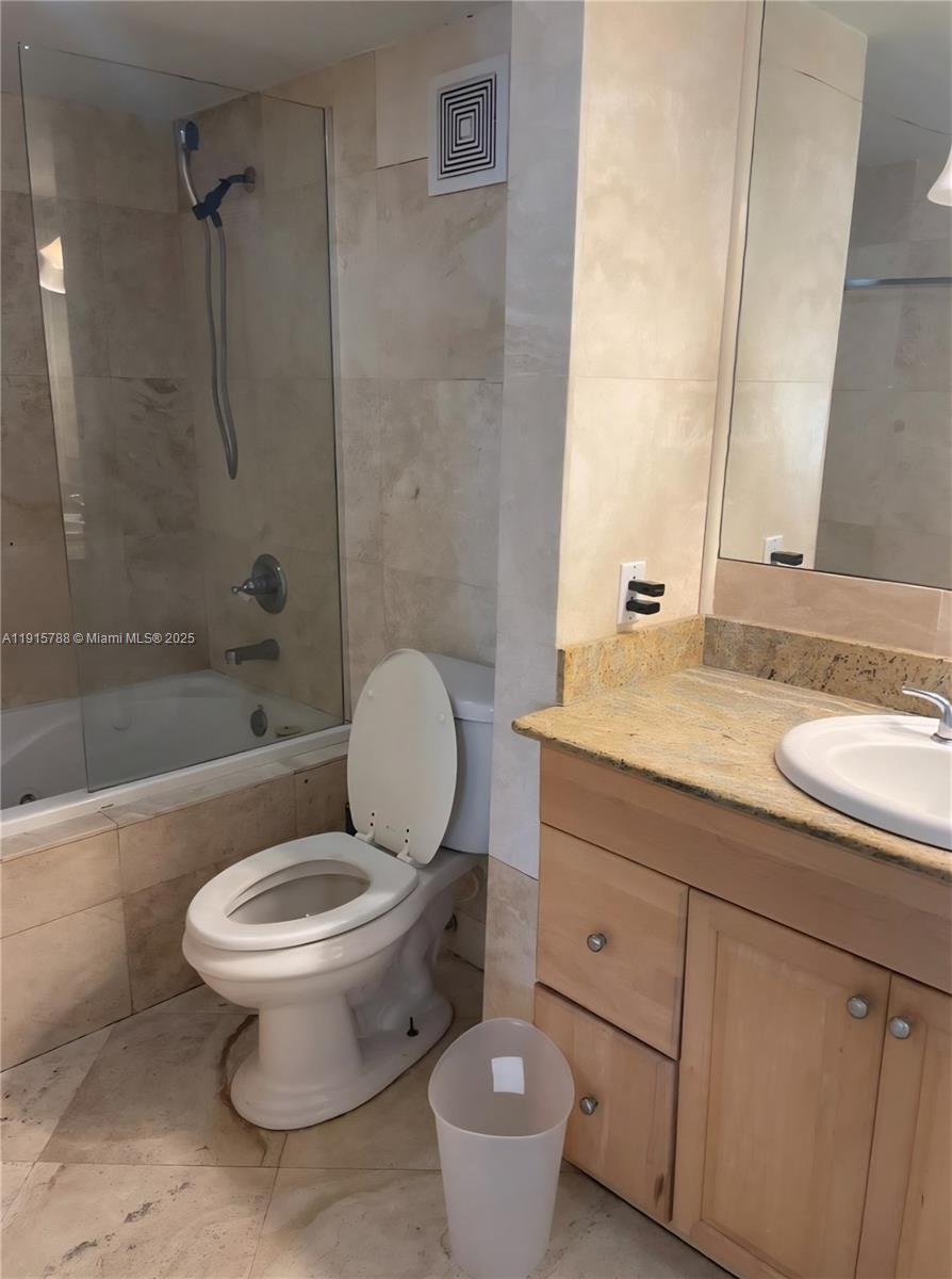 250 180th Drive, Unit 510 Sunny Isles Beach, FL 33160 - Photo 12 of 19 a bathroom with a granite countertop toilet a sink and a bathtub