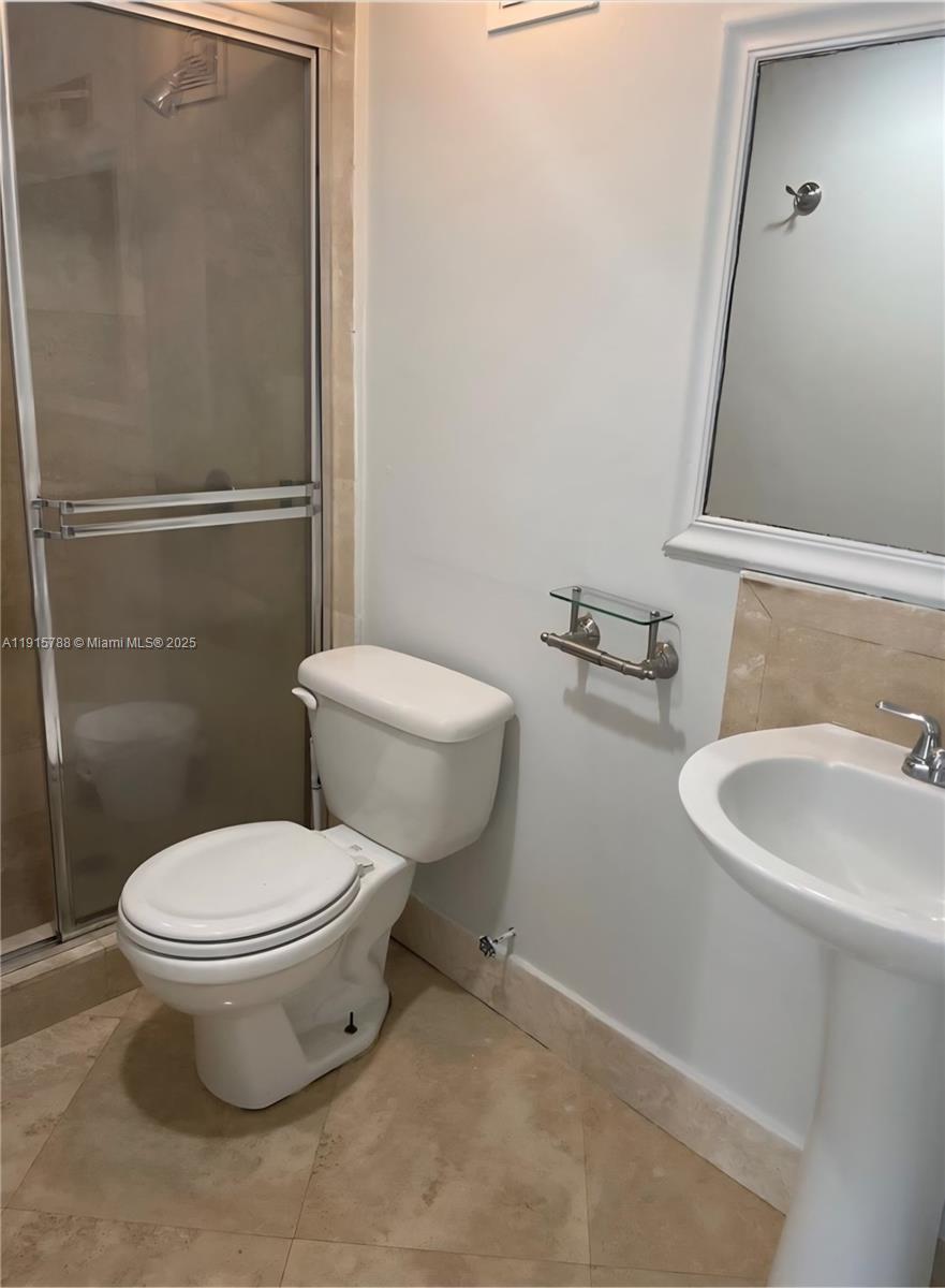 250 180th Drive, Unit 510 Sunny Isles Beach, FL 33160 - Photo 18 of 19 a white toilet sitting next to a bathroom sink