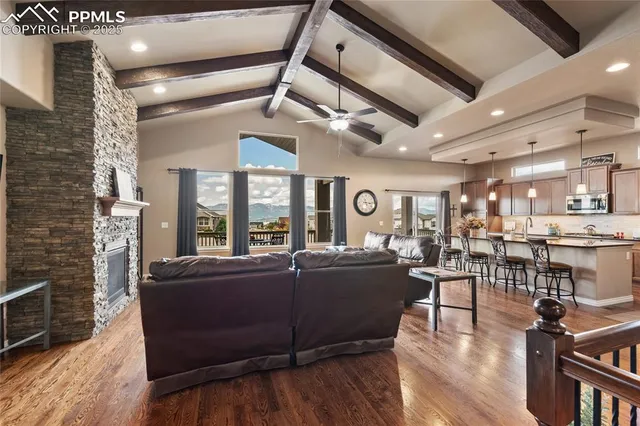 a living room with furniture a fireplace and a large window