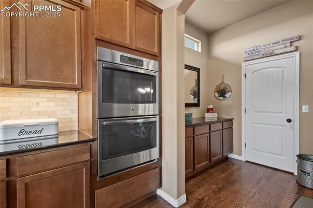 a kitchen with stainless steel appliances granite countertop a sink a stove and a wooden floors