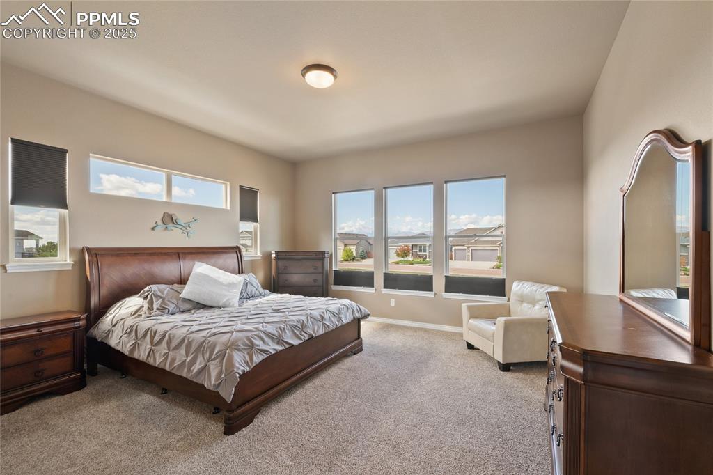 3718 Sky Rim Court Colorado Springs, CO 80908 - Photo 24 of 49 a bedroom with a bed and large windows