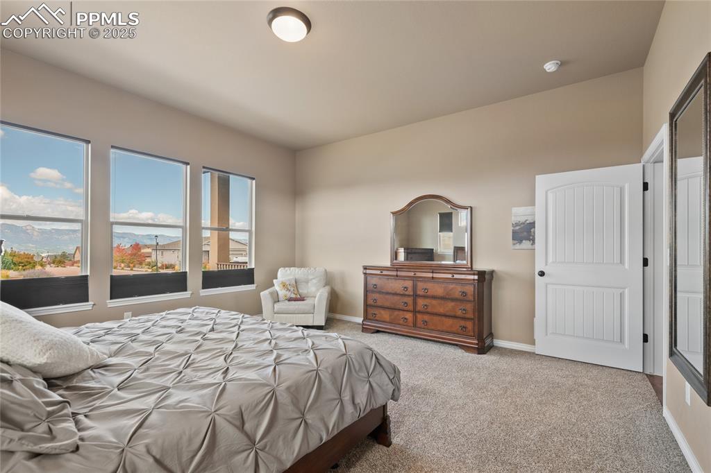 3718 Sky Rim Court Colorado Springs, CO 80908 - Photo 26 of 49 a bedroom with a bed and large window