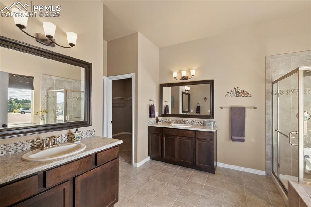 3718 Sky Rim Court Colorado Springs, CO 80908 - Photo 27 of 49 a spacious bathroom with a granite countertop sink and a mirror