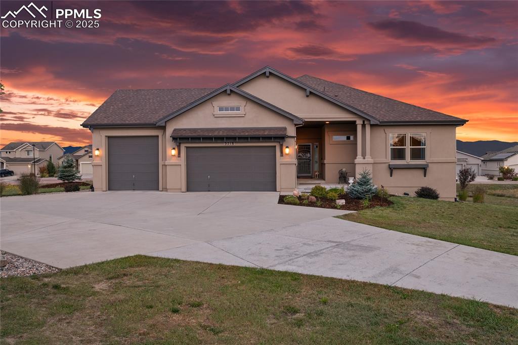 3718 Sky Rim Court Colorado Springs, CO 80908 - Photo 4 of 49 a front view of a house with a yard and garage