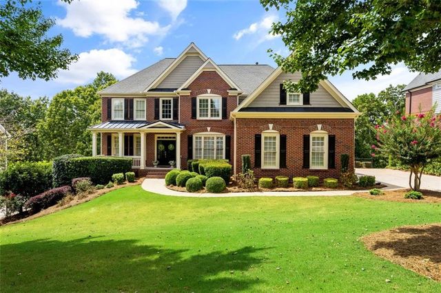 a front view of a house with a yard porch and outdoor seating