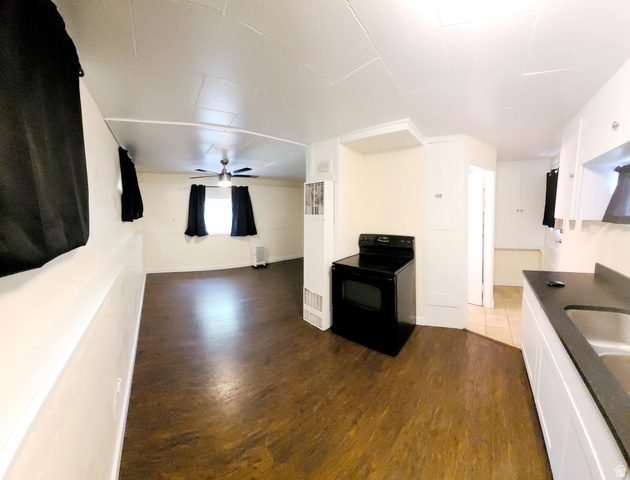 684 East 400 North Logan, UT 84321 - Photo 20 of 27 Open-concept living space with wood-finish flooring, a ceiling fan, and a black range