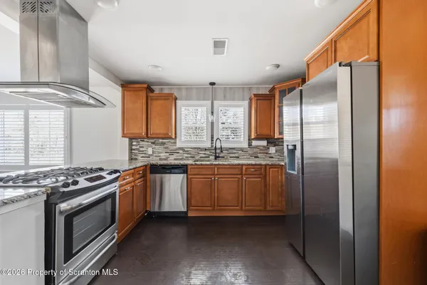 a kitchen with stainless steel appliances granite countertop a stove a sink and a refrigerator
