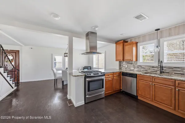 a kitchen with stainless steel appliances granite countertop a stove and a sink