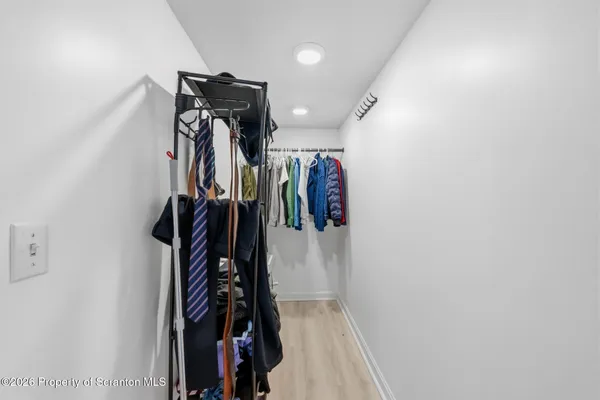 a view of walk in closet with clothes