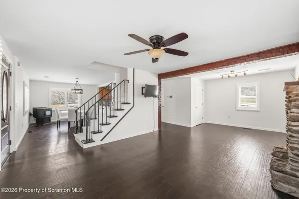 a view of a livingroom with wooden floor and a ceiling fan