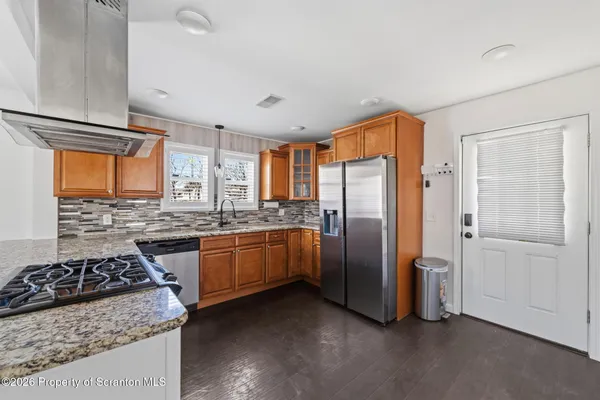 a kitchen with stainless steel appliances granite countertop a stove a refrigerator and a stove