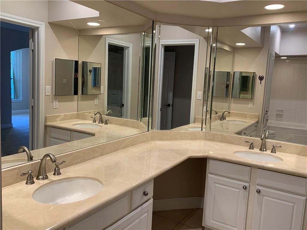 7701 Rialto Boulevard, Unit 1222 Austin, TX 78735 - Photo 7 of 14 A pristine primary bathroom features dual sinks with ample counter space and mirrored walls, offering both style and function.