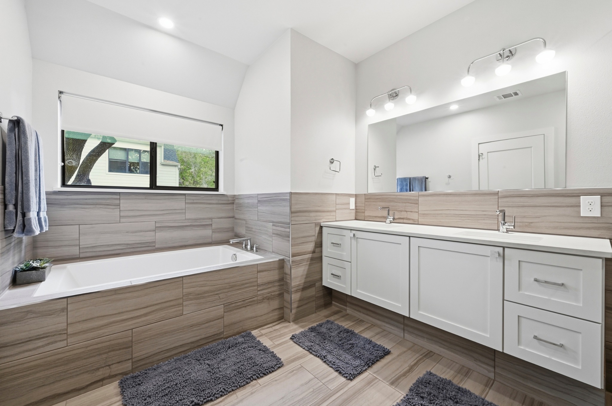 3115 Clawson Road, Unit 201 Austin, TX 78704 - Photo 19 of 34 Soaking tub with a tiled surround, complemented by a large window