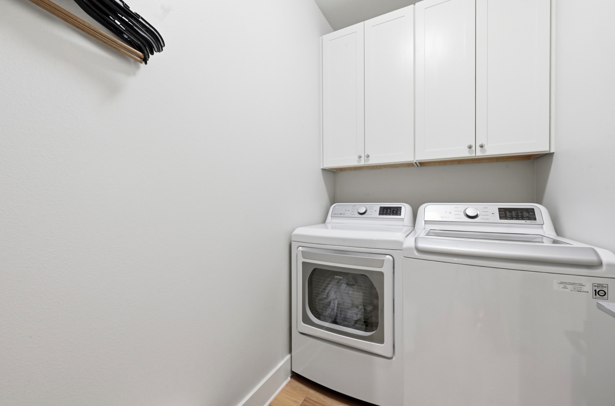 3115 Clawson Road, Unit 201 Austin, TX 78704 - Photo 24 of 34 Dedicated laundry area featuring white upper cabinetry, light wood-finish flooring, and light-toned walls