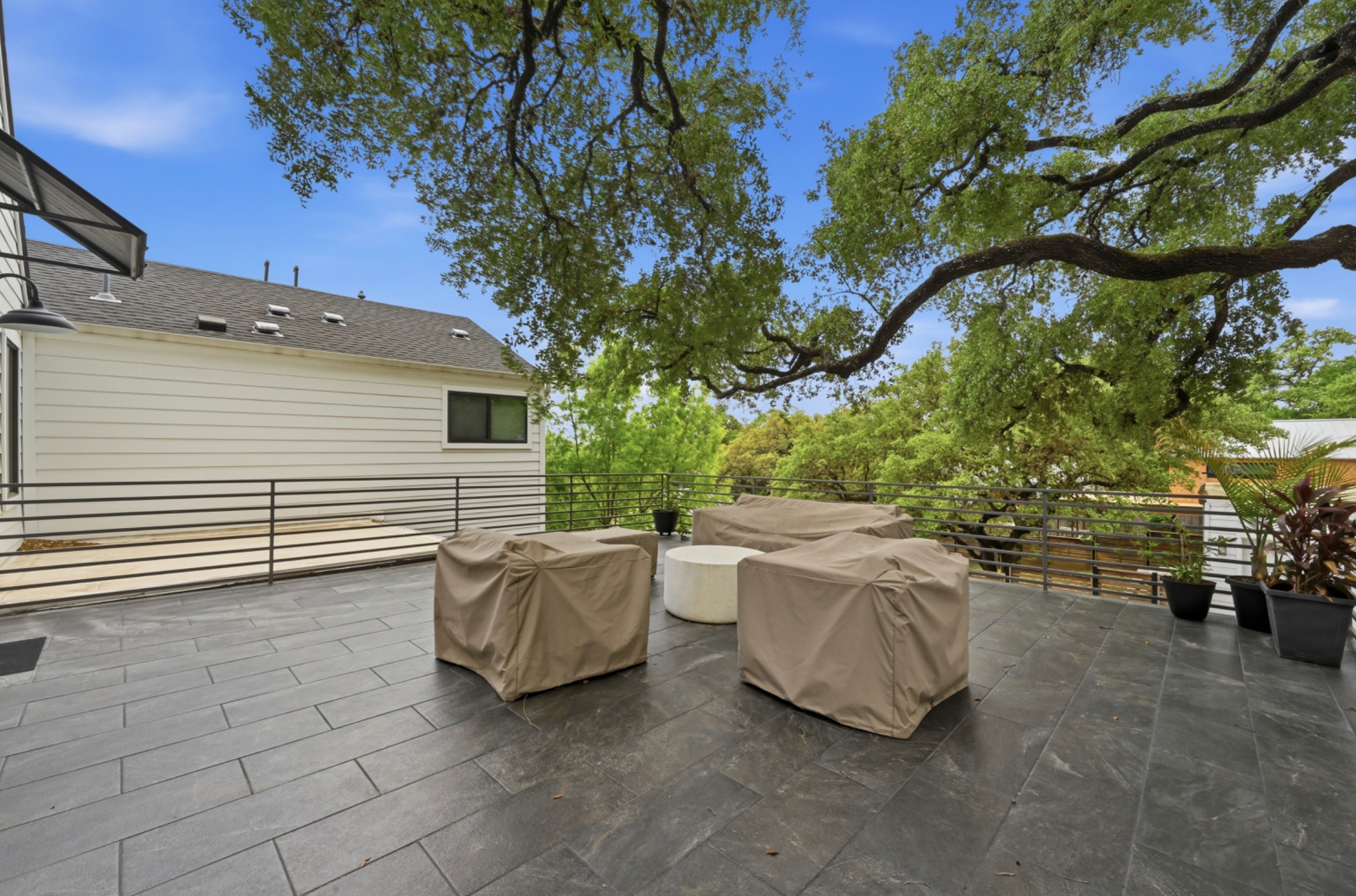 3115 Clawson Road, Unit 201 Austin, TX 78704 - Photo 27 of 34 Spacious outdoor patio featuring large-format dark grey tile flooring and a horizontal metal railing
