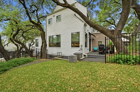 a view of house with backyard and outdoor seating