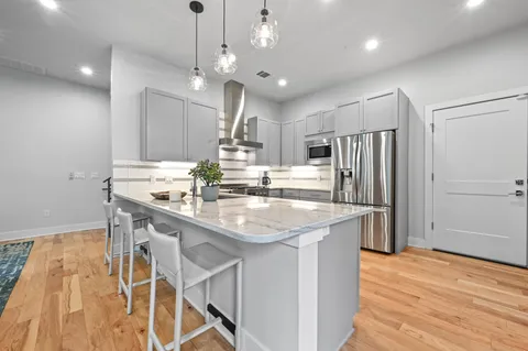 a kitchen with kitchen island a sink stove and refrigerator