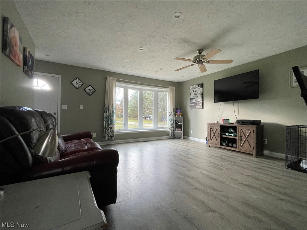 9104 Cherry Road Vermilion, OH 44089 - Photo 9 of 27 Living room with ceiling fan with a bay window for natural sun light.