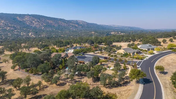 an aerial view of a house with a mountain