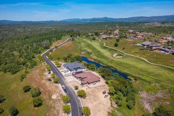 an aerial view of residential house with outdoor space and trees all around