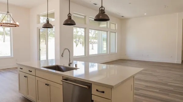 a kitchen with stainless steel appliances a sink a window and cabinets