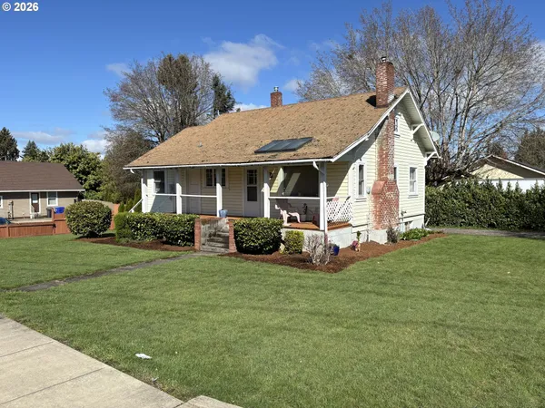 a view of a house with a yard and sitting area