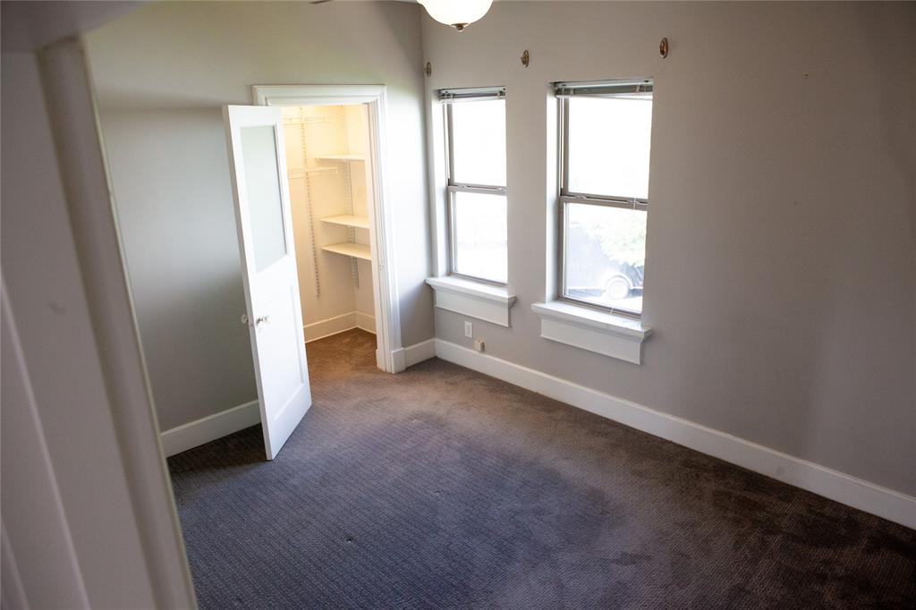 5347 Lewis Street, Unit 5345 Dallas, TX 75206 - Photo 21 of 37 Secondary bedroom featuring double windows, oversized closet with custom shelving and lush carpeting.