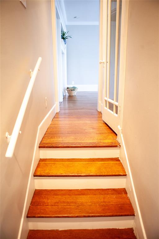 5347 Lewis Street, Unit 5345 Dallas, TX 75206 - Photo 7 of 37 Warm oak flooring stairs welcome you and your guests to the light-filled space. Laundry closet is through the glass door on the right.
