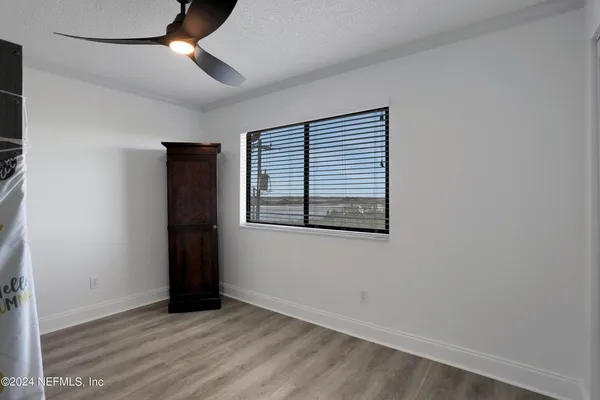 an empty room with window and ceiling fan