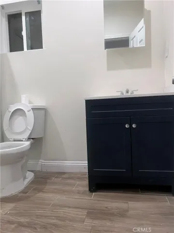 a bathroom with a toilet a sink and mirror