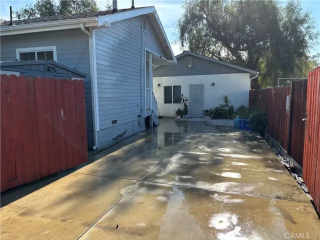 a backyard of a house with chairs and wooden fence