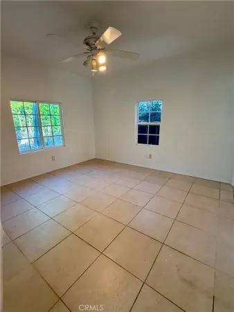 a view of a room with windows and ceiling fan