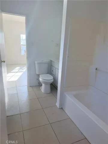 a spacious bathroom with a bathtub and toilet