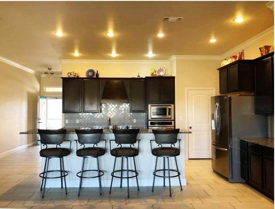 3641 Ridgely Lubbock, TX 79407 - Photo 3 of 10 a kitchen with stainless steel appliances a dining table chairs refrigerator and cabinets