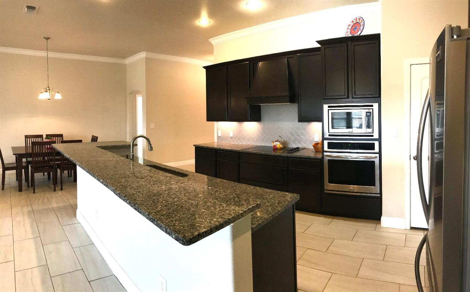 3641 Ridgely Lubbock, TX 79407 - Photo 5 of 10 a kitchen with stainless steel appliances a kitchen island wooden cabinets and granite counter tops