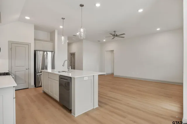 a kitchen with stainless steel appliances granite countertop a sink a stove and a refrigerator