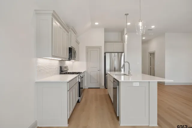 a kitchen with kitchen island a sink stove and refrigerator
