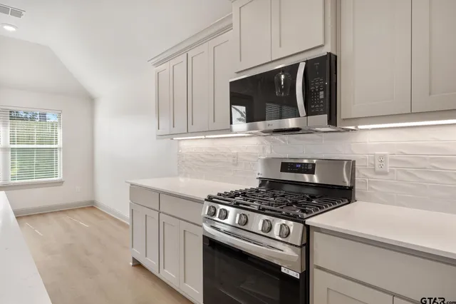 a kitchen with microwave cabinets and stove top oven