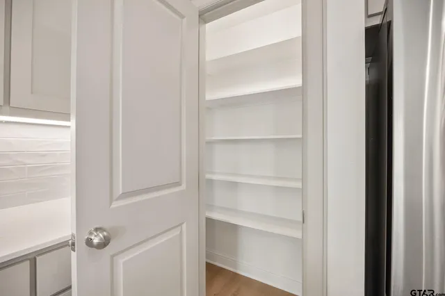 a view of walk in closet with empty racks