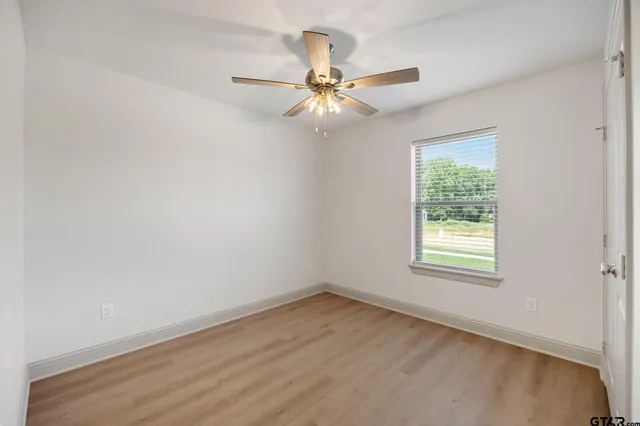 an empty room with a window and a fan